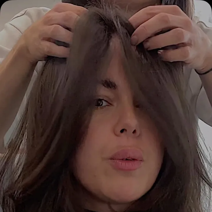 Stylist lifting long dark brunette hair to show its movement