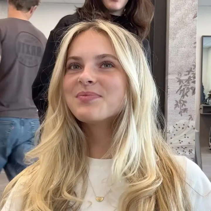 Blonde client and stylist inside the salon